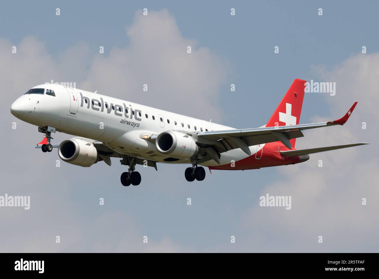 Un aeroplano in una livrea rossa e bianca colpisce il cielo aperto Foto Stock