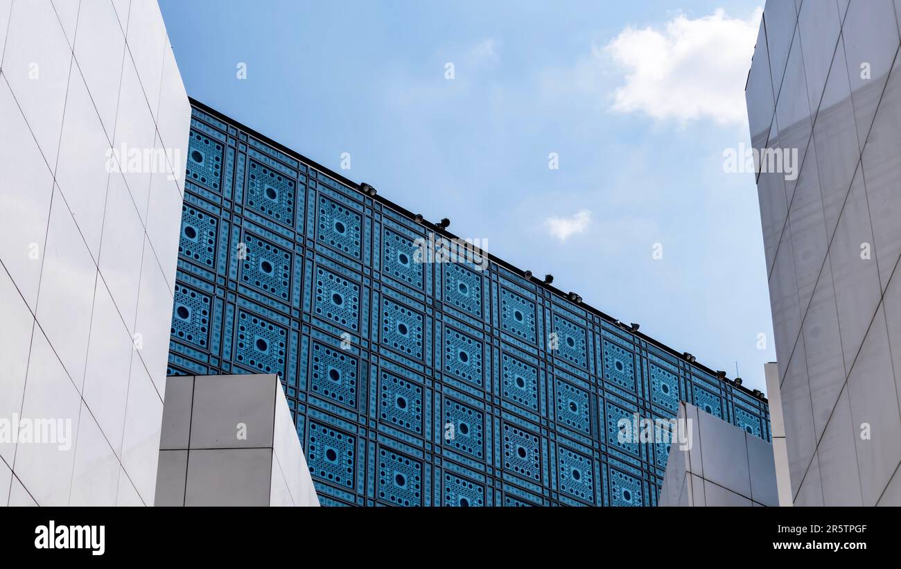 Un edificio decorato costruito con blocchi di vetro blu a motivi geometrici, illuminati dal sole Foto Stock