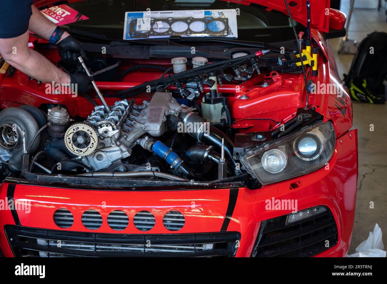 Un primo piano di una terza generazione rossa Volkswagen Scirocco in officina Foto Stock