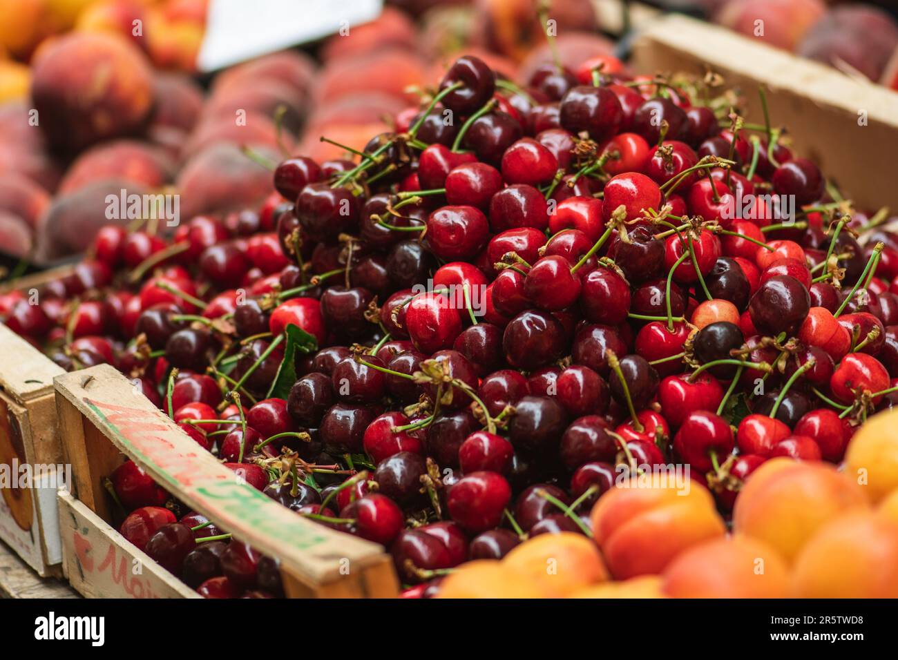 Frutta fresca matura di ciliegia rossa o ciliegie in una scatola di legno in un mercato agricolo all'aperto, cibo stagionale sano. Concetto di biologico, bio Foto Stock