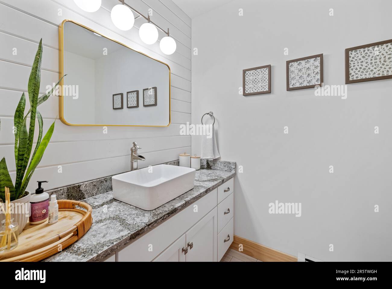 Una stanza da bagno contemporanea presenta un piano vanity in marmo bianco con un lavandino Foto Stock