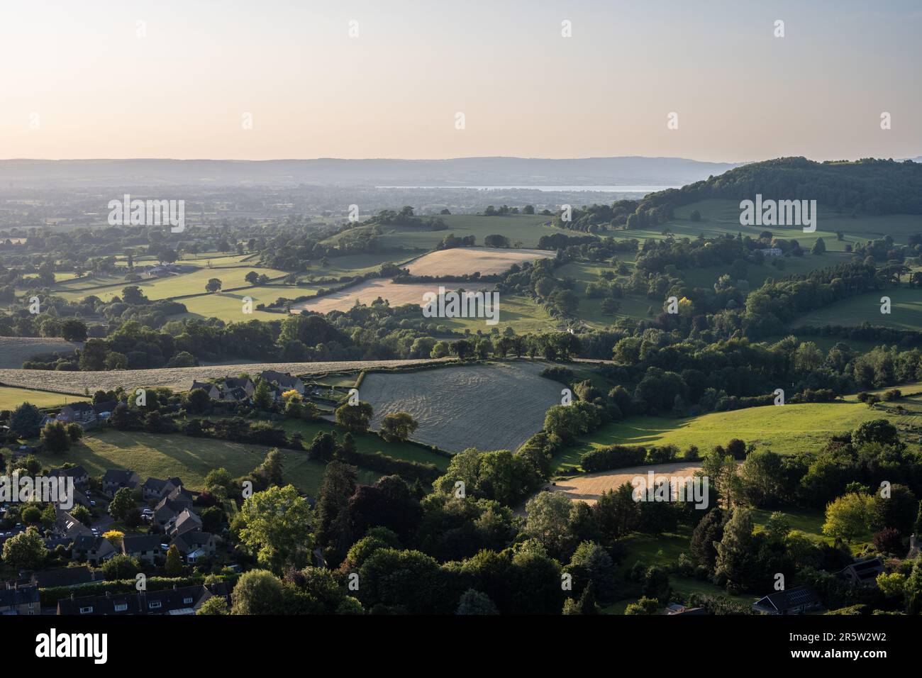 Il sole serale splende sul paesaggio pastorale della valle di Severn sotto il margine di Cotswolds a Nibley nord nel Gloucestershire, con l'estuario di Severn Foto Stock