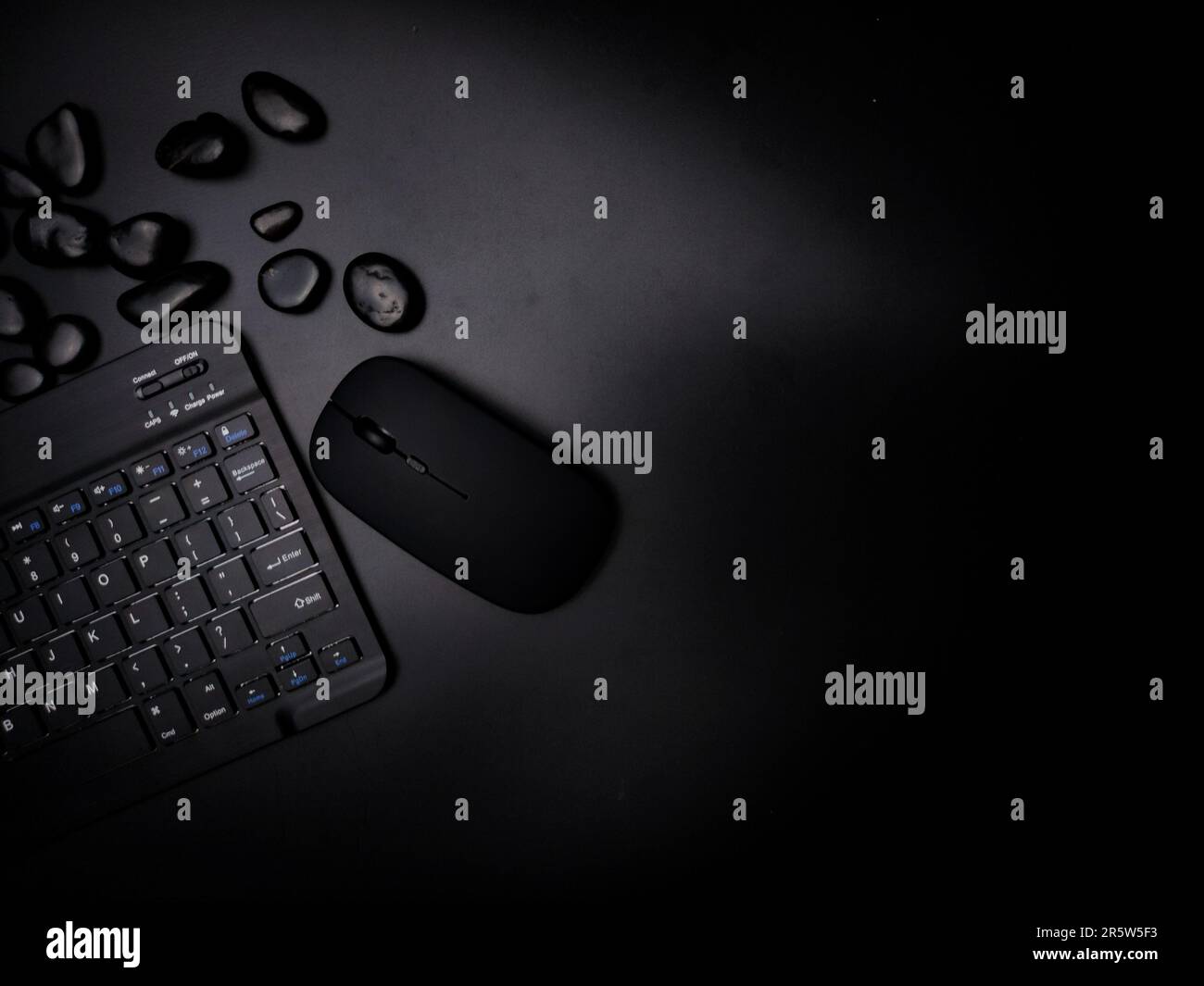Immagine di un mouse e di una tastiera elettronici posizionati su un tavolo accanto ad altri oggetti Foto Stock