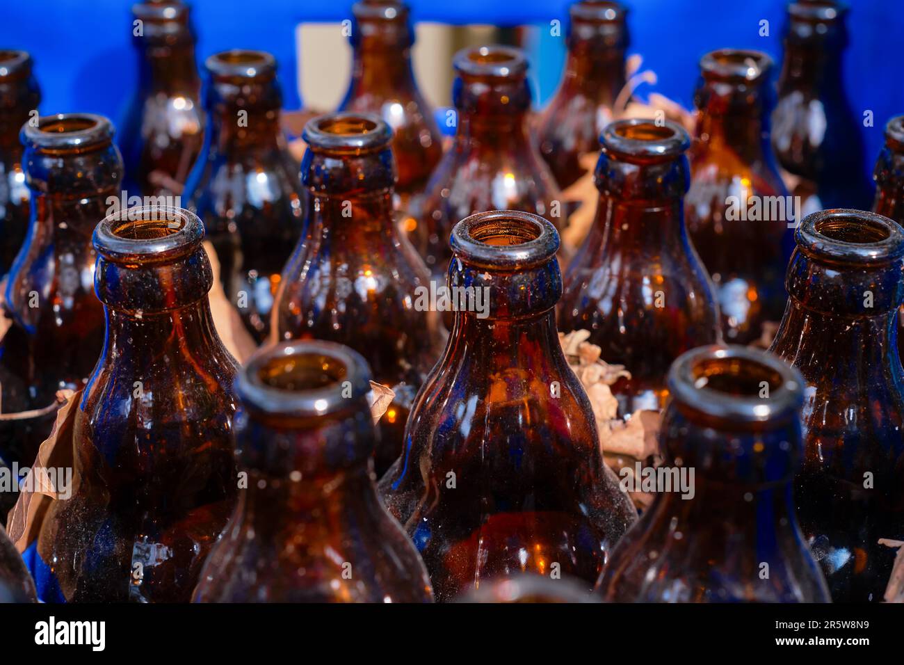 Birra vuota bottiglie sporche in un cassetto accanto a un bar o bar, focalizzazione selettiva, riciclaggio di materiali e riutilizzo di bottiglie di vetro Foto Stock