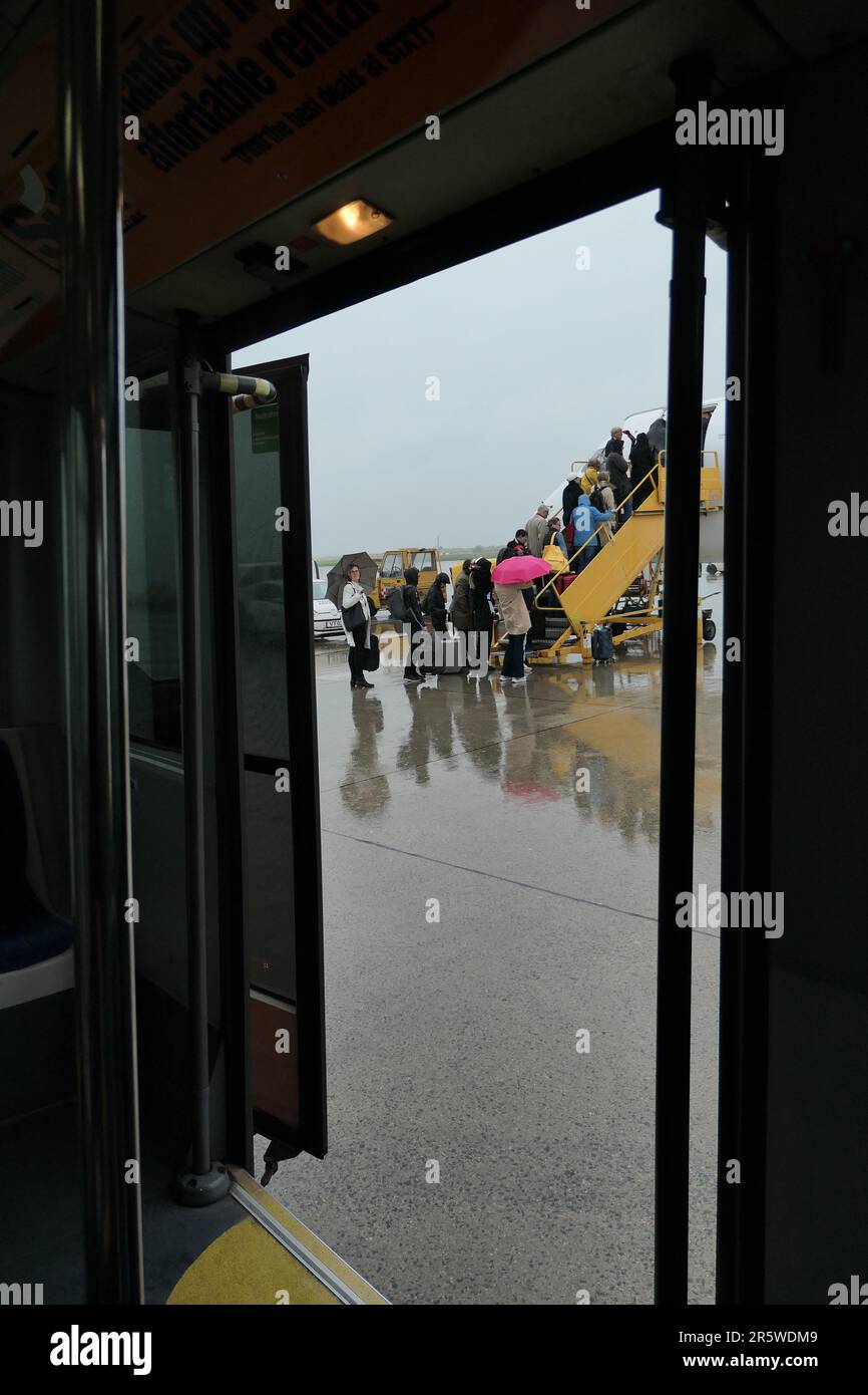 Flugreise, Passagiere betreten ein Flugzeug bei Regen // viaggio aereo, passeggeri a bordo di un aereo sotto la pioggia Foto Stock