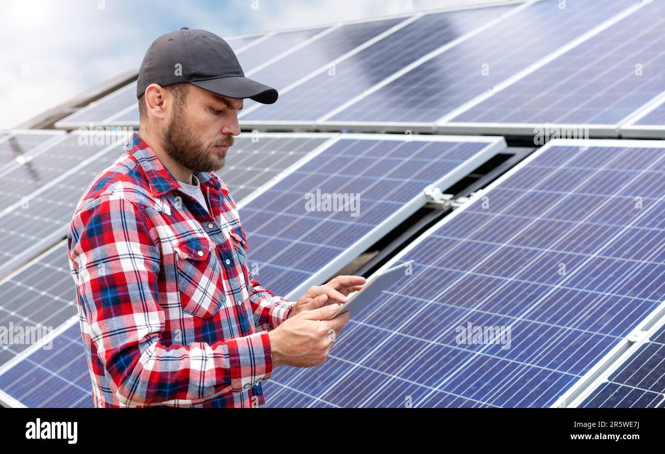 Il tecnico sul campo esegue la diagnostica della stazione di energia solare utilizzando un tablet digitale wireless. Foto Stock