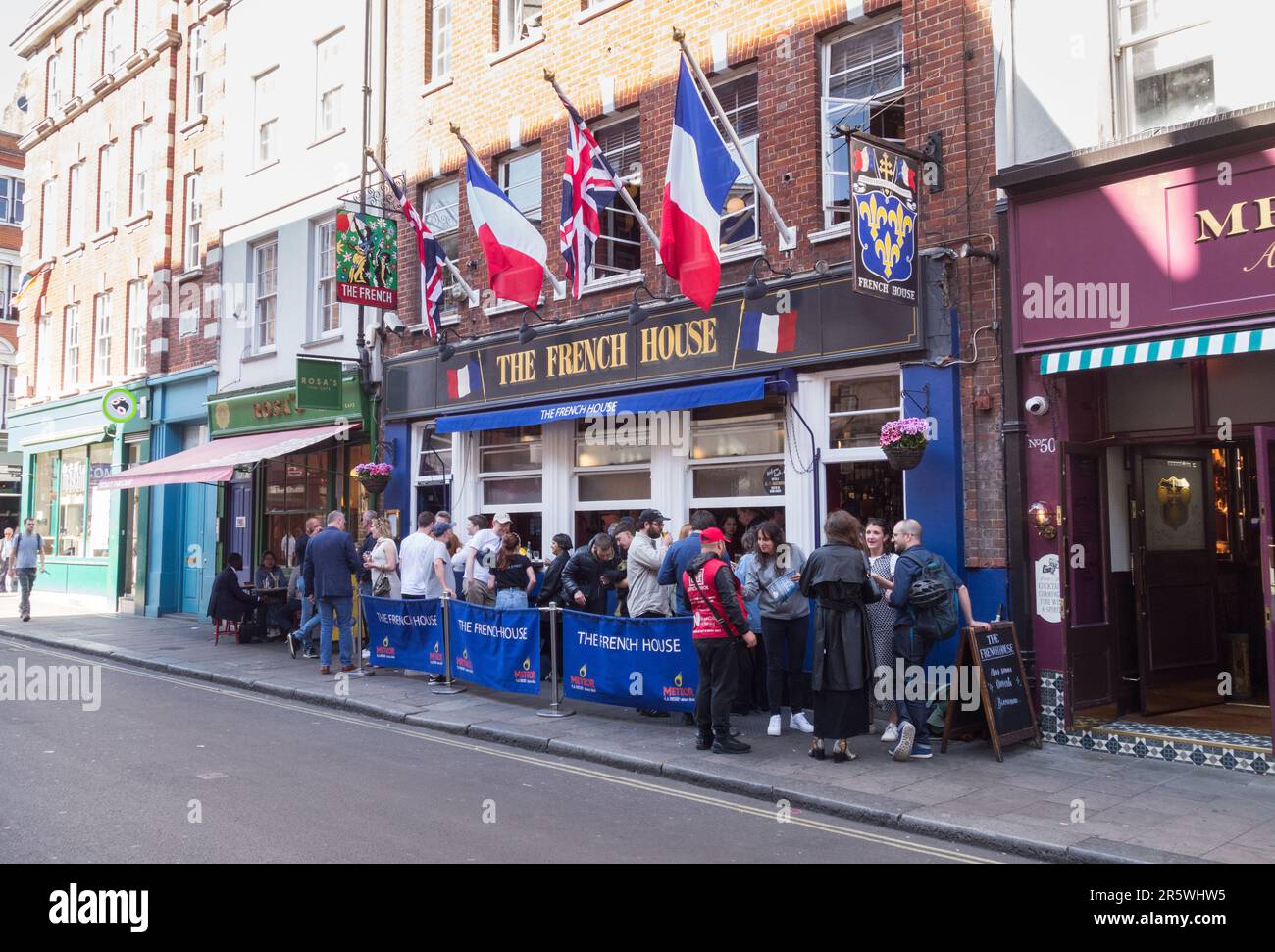 Tricolors e Union Jacks che volano all'esterno del pub French House in Dean Street, Soho, Londra, W1, Inghilterra, REGNO UNITO Foto Stock