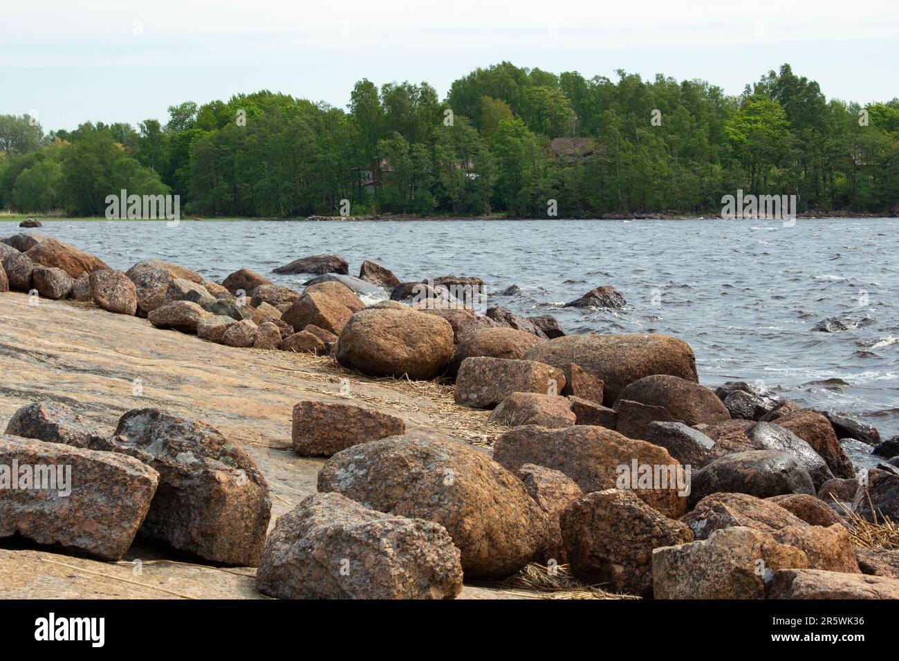 La riva del Golfo di Finlandia. Sulla roccia si trovano grandi massi di granito. Il mare calmo. La natura aspra del nord. Foto Stock