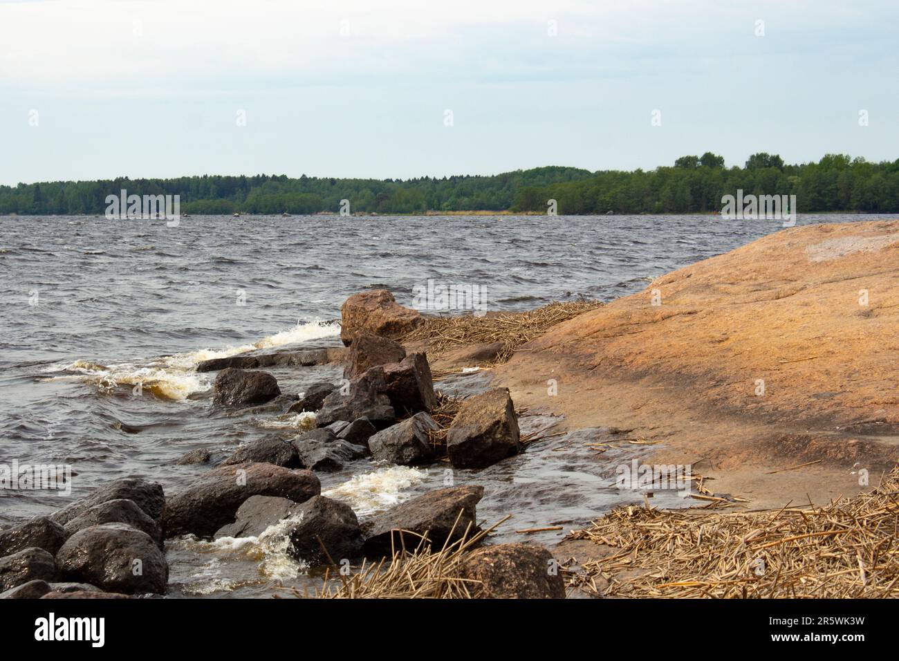 La riva del Golfo di Finlandia. Sulla roccia si trovano grandi massi di granito. Il mare calmo. La natura aspra del nord. Foto Stock