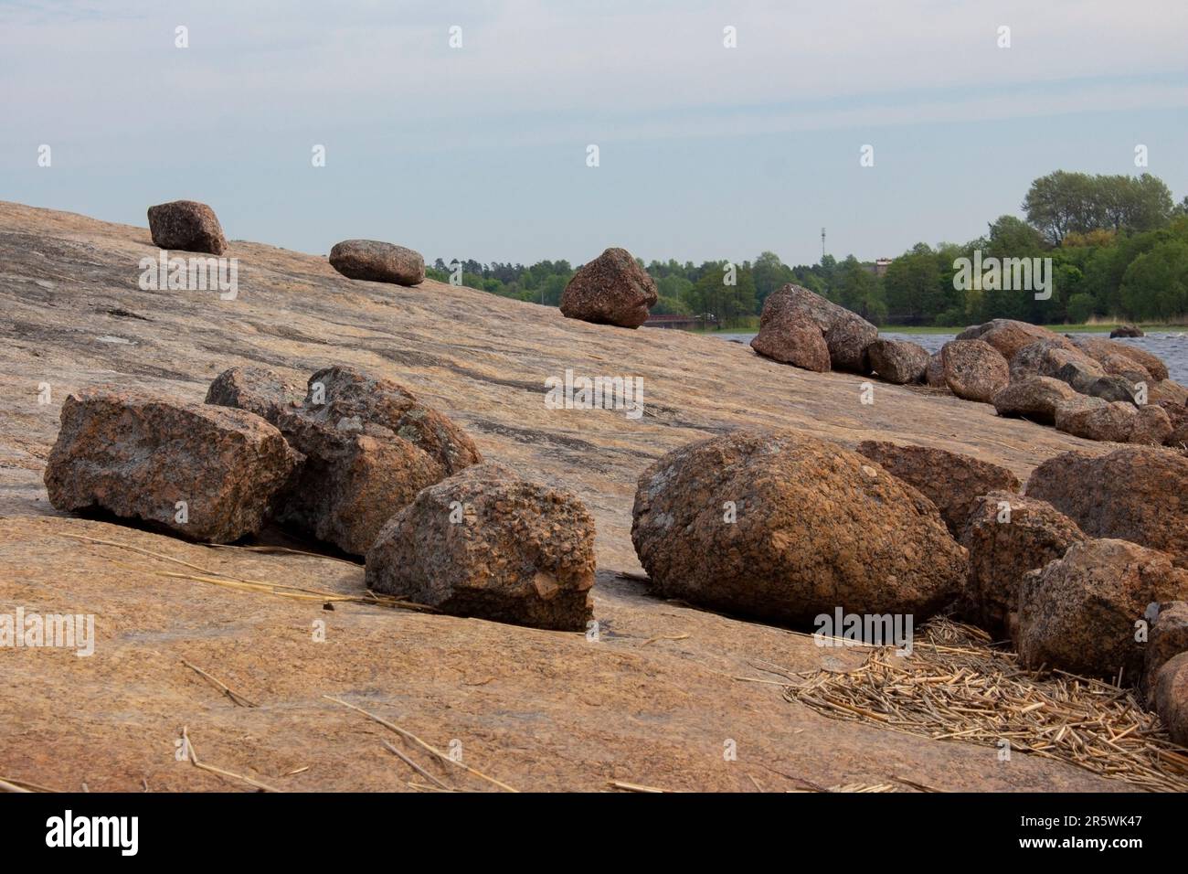 La riva del Golfo di Finlandia. Sulla roccia si trovano grandi pietre-massi di granito. La natura aspra del nord. Foto Stock