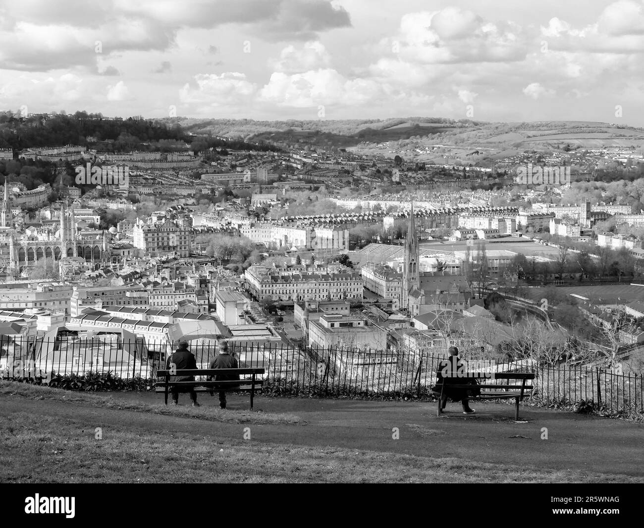 La gente che siede su panche di legno godendo del paesaggio urbano di Bath. Inghilterra, Regno Unito. Foto Stock