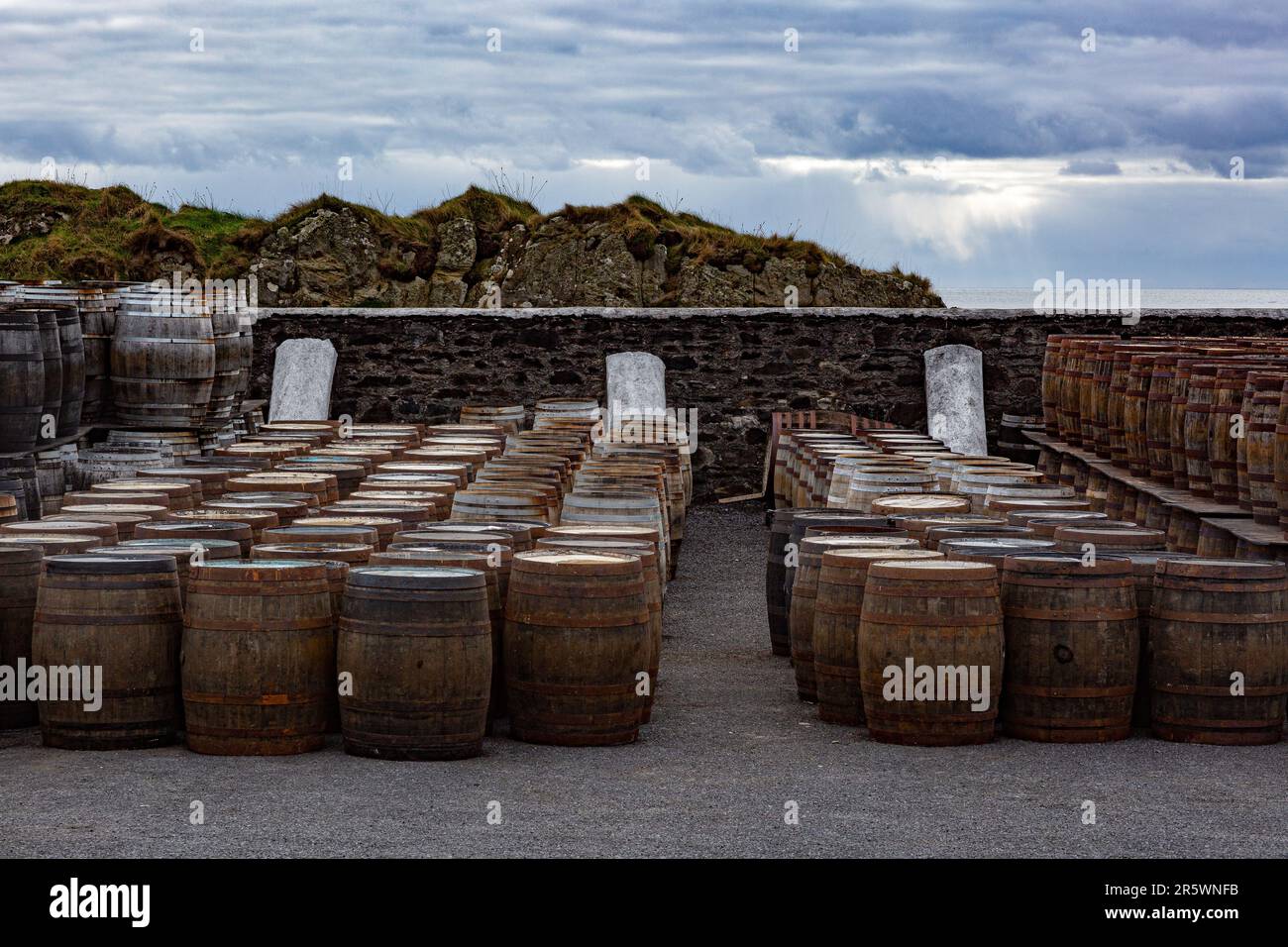 Vecchie botti di legno e botti stanno sotto il cielo aperto maturando alla Distilleria Ardbeg, Isola di Islay, Ebridi interne, Scozia, Regno Unito Foto Stock