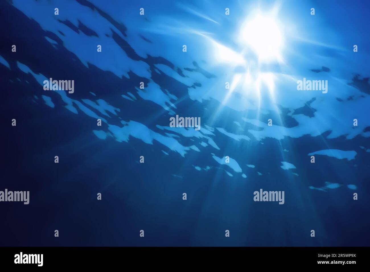 Luce solare subacquea attraverso la superficie dell'acqua, sfondo subacqueo Foto Stock