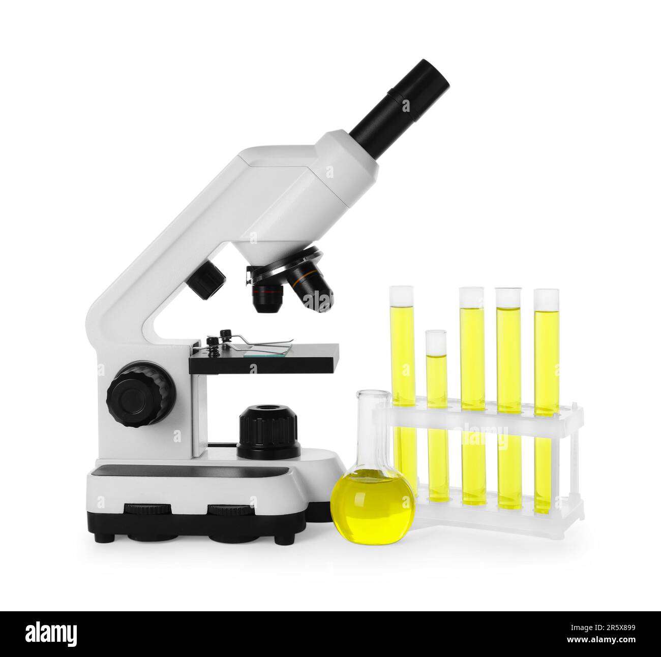 Vetreria da laboratorio con liquido giallo e microscopio isolato su bianco Foto Stock