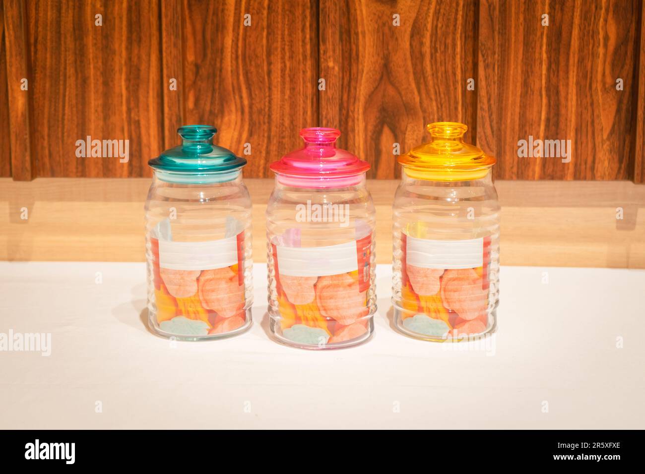 I vasetti colorati in vetro con coperchi sono perfetti per conservare e organizzare una varietà di articoli. Con le loro vivaci sfumature e il design pratico, offrono un st Foto Stock I vasetti colorati in vetro con coperchi sono perfetti per conservare e organizzare una varietà di articoli. Con le loro vivaci sfumature e il design pratico, offrono un st Foto Stock