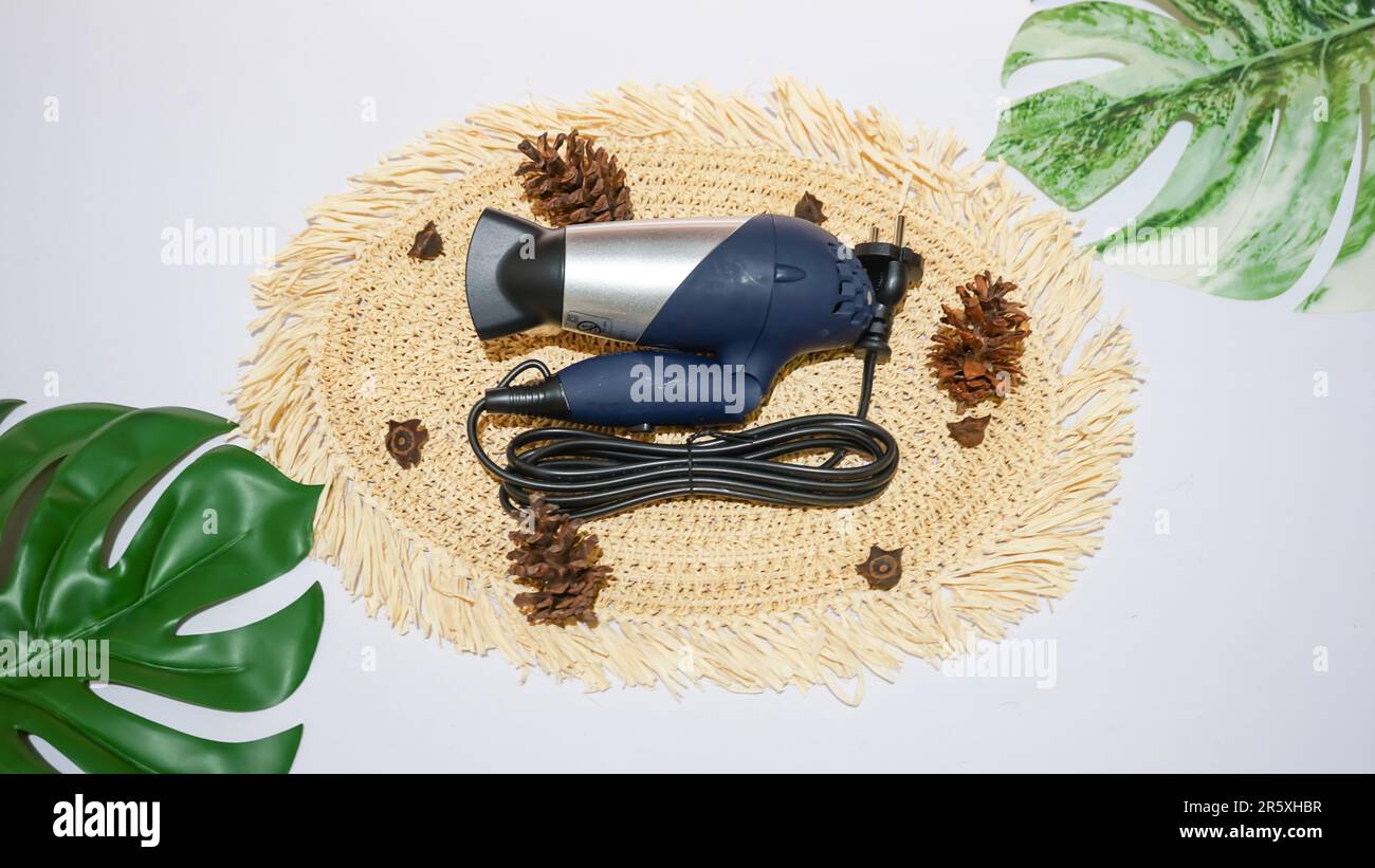 Un asciugacapelli blu scuro è uno strumento pratico per asciugare e acconciare i capelli in modo rapido e semplice. Foto Stock