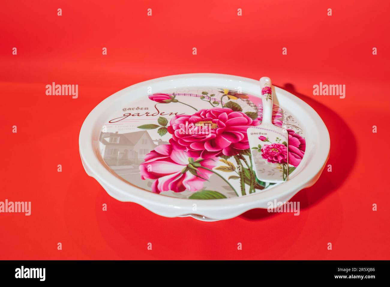 Il supporto per torta rotonda in ceramica bianca con motivo floreale è un punto di riferimento straordinario per i tuoi dessert. Il supporto per torta rotonda in ceramica bianca con motivo floreale Foto Stock