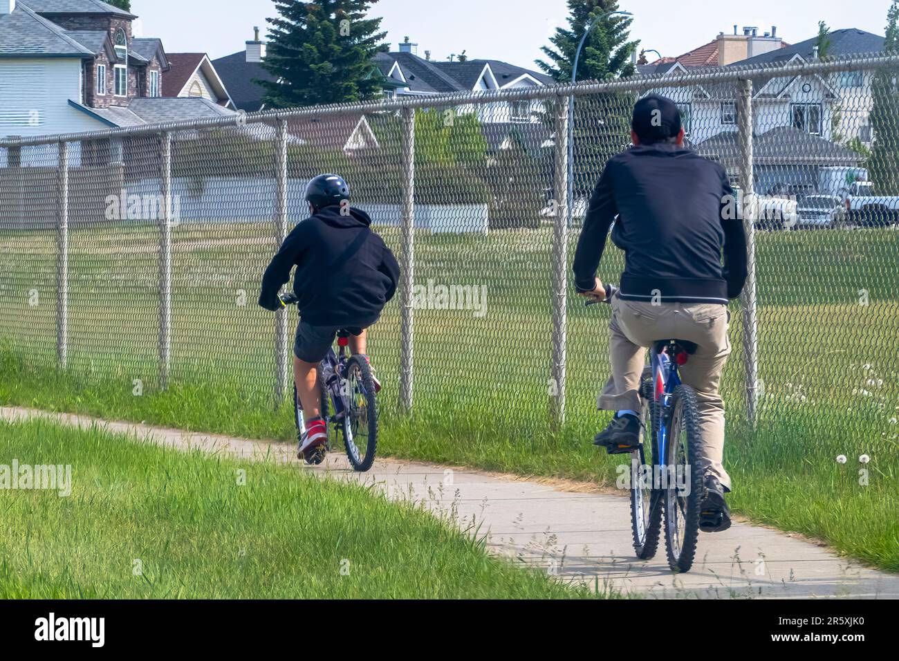 Calgary, Alberta, Canada. 4 giugno 2023. Un paio di persone in bicicletta su un sentiero durante la primavera. Foto Stock