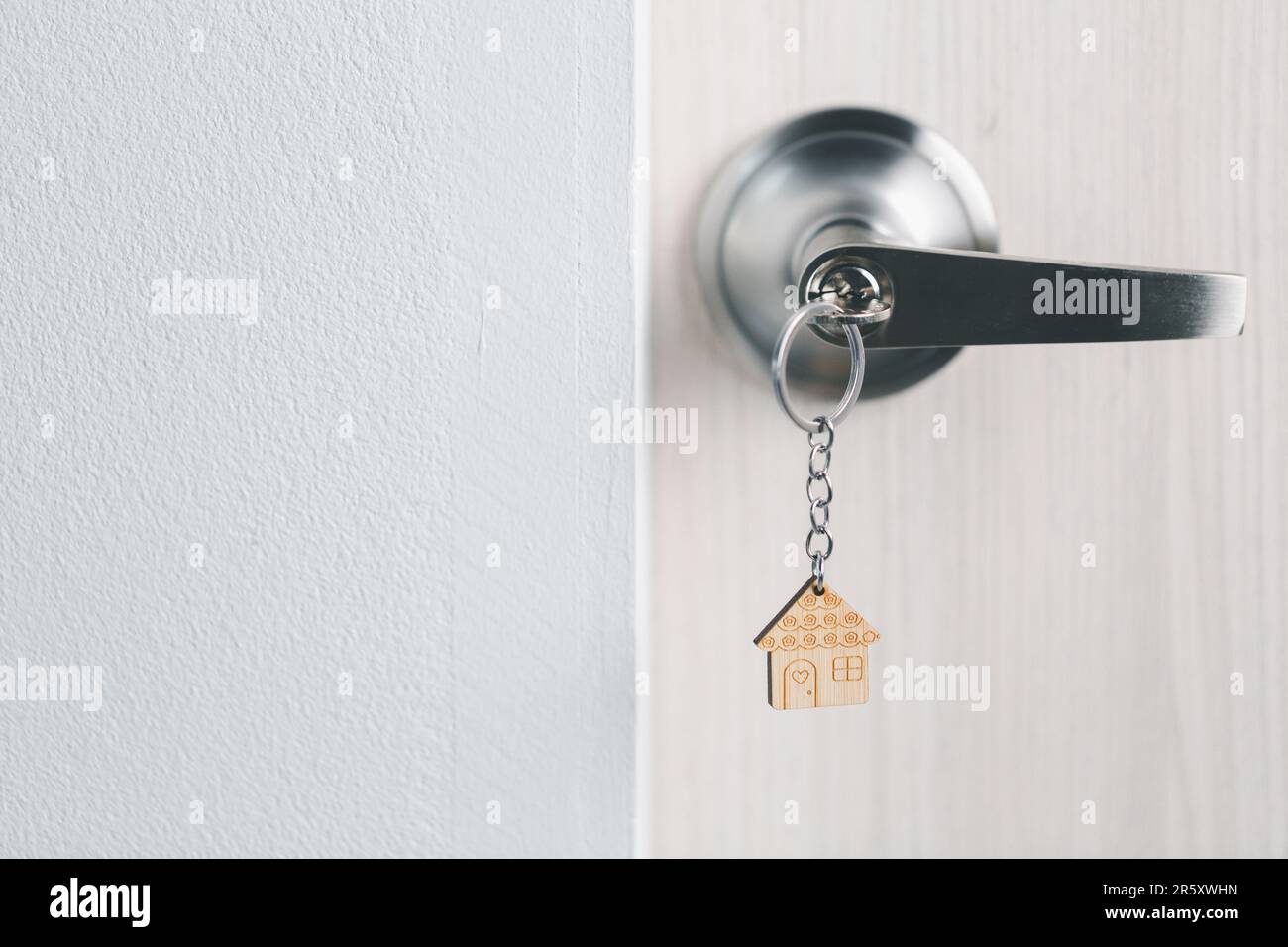 primo piano sulla chiave della porta con luce del mattino, concetto di prestito personale. Modello di casa e chiave in casa porta. Agenzia immobiliare offerta casa, assicurazione immobiliare Foto Stock