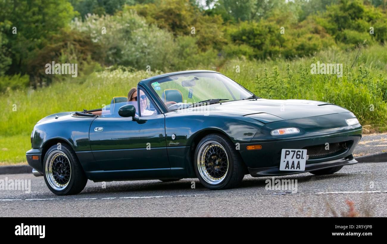 Stony Stratford, Regno Unito - Giugno 4th 2023: 1996 auto classica MAZDA MX-5 verde che viaggia su una strada di campagna inglese. Foto Stock