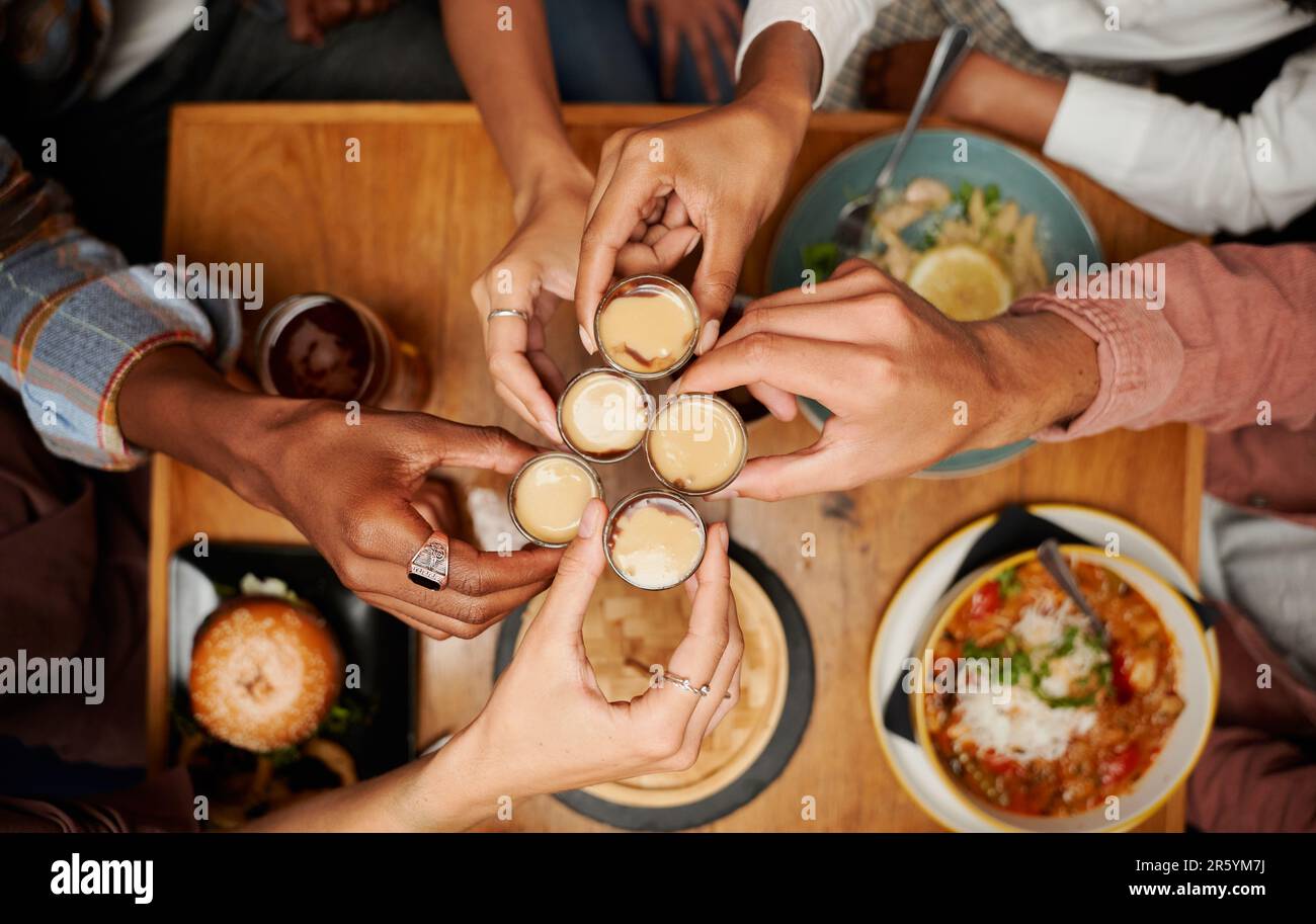 Primo piano di un giovane gruppo multirazziale di amici in abbigliamento informale che brinda con bevande al ristorante Foto Stock