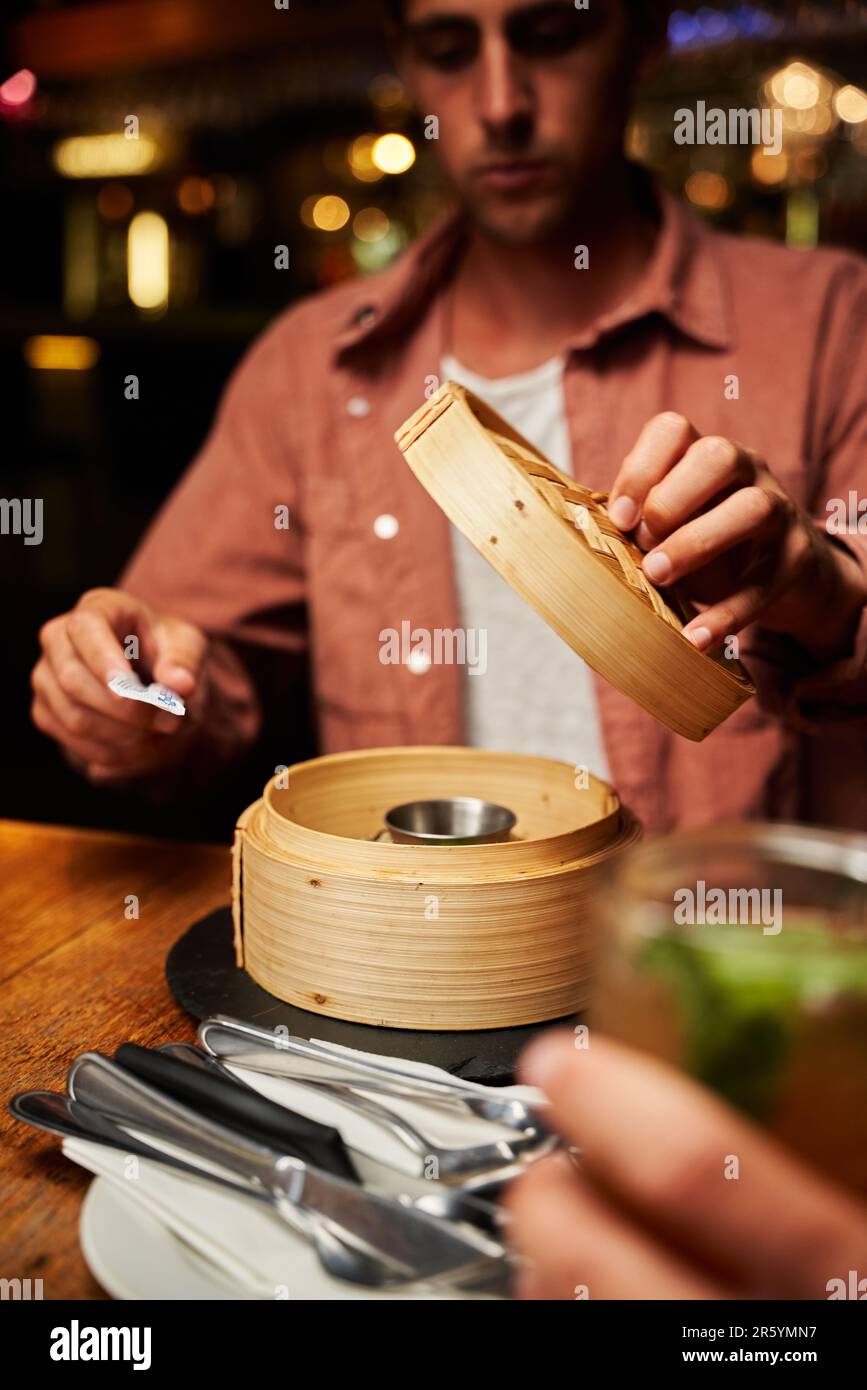 Primo piano di giovani coppie caucasiche in abbigliamento informale con cibo e bevande al ristorante Foto Stock