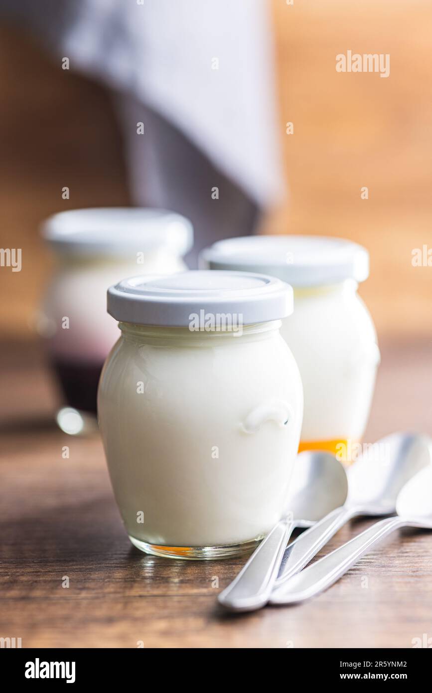 Yogurt bianco in vaso sul tavolo di legno. Foto Stock