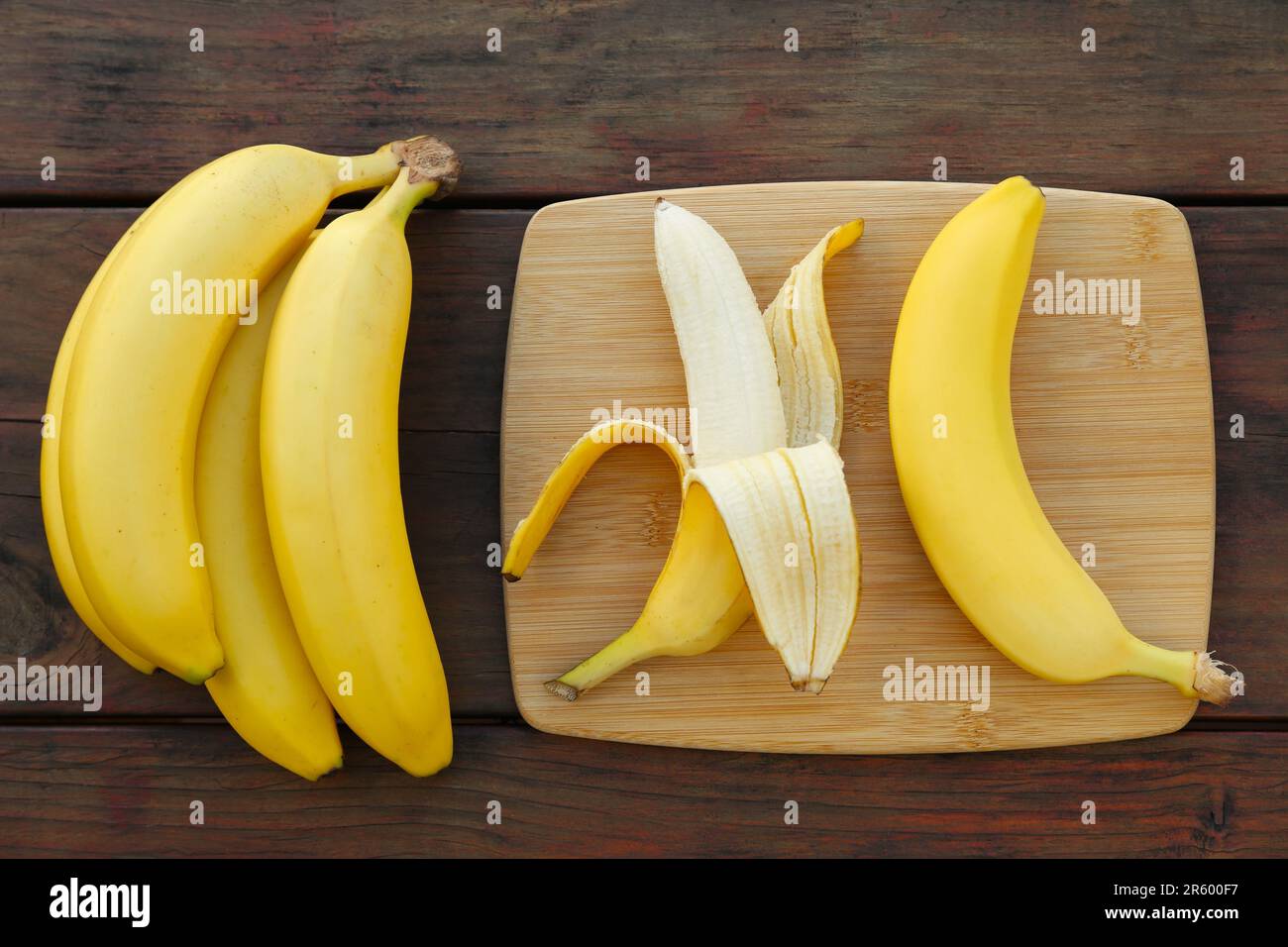 Deliziose banane su tavolo di legno, piatto Foto Stock