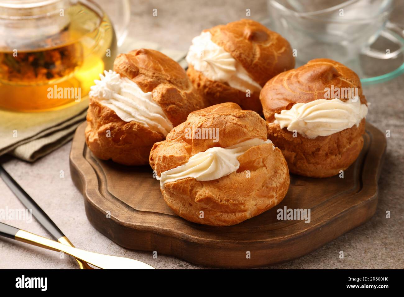 Deliziosi profiteroles ripieni di crema sul tavolo grigio Foto Stock