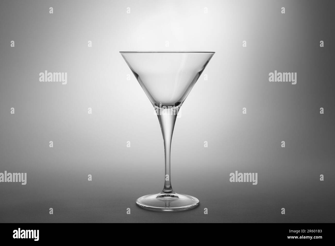 Elegante bicchiere martini vuoto su sfondo grigio Foto Stock