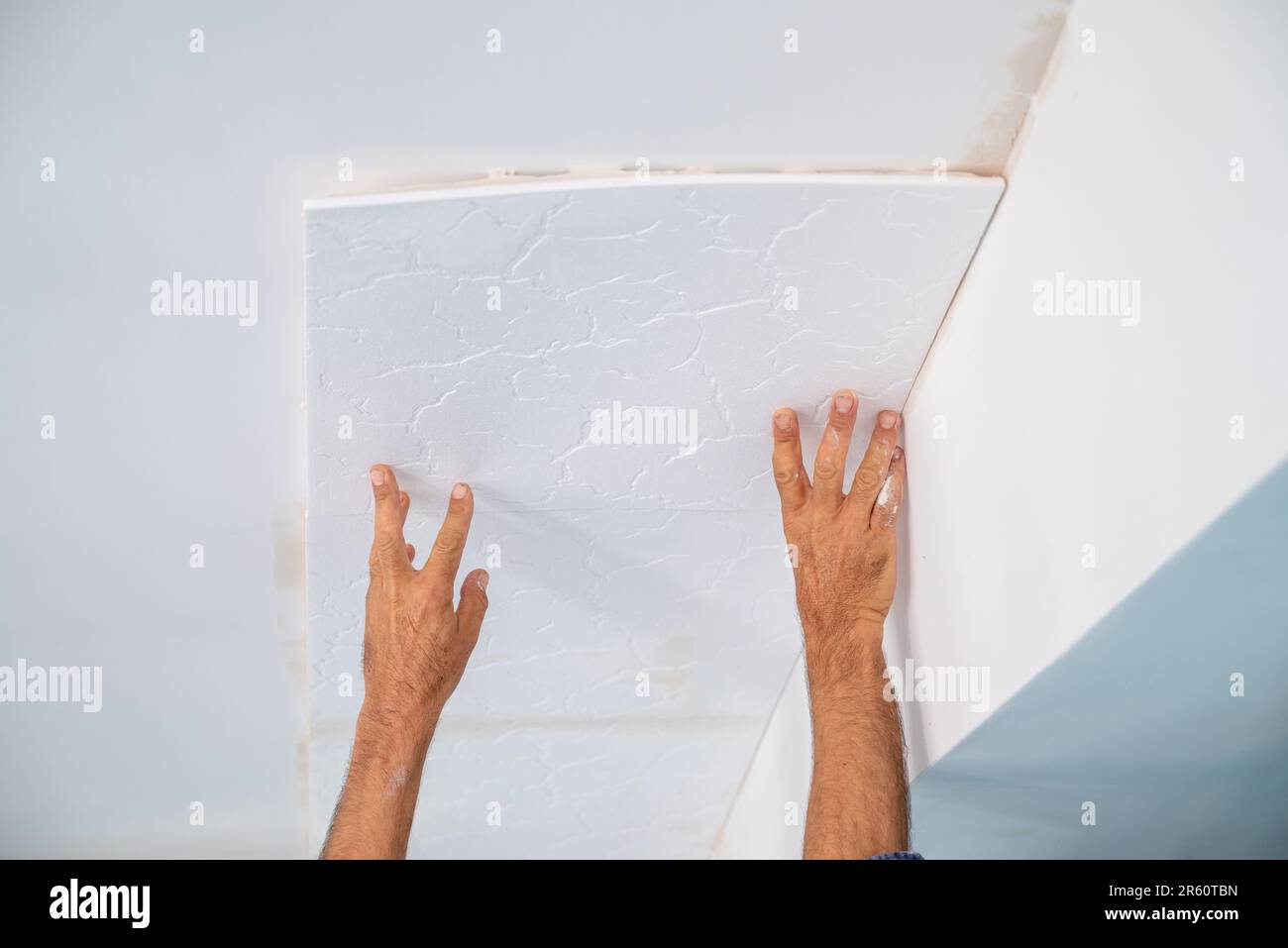 applicazione di intonaco adesivo di piastrelle styrofoam soffitto di una cucina domestica Foto Stock