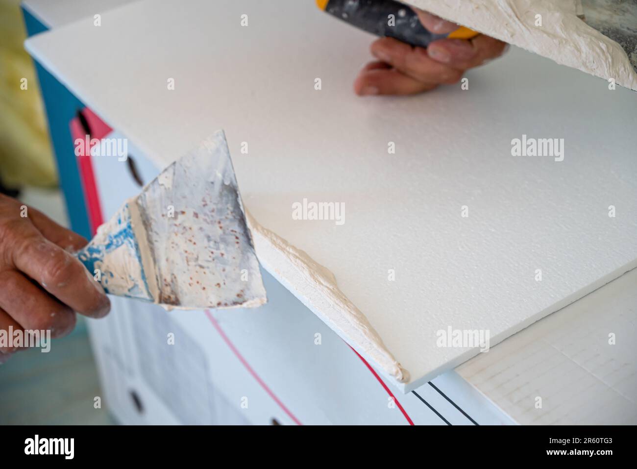 applicazione di intonaco adesivo di piastrelle styrofoam soffitto di una cucina domestica Foto Stock