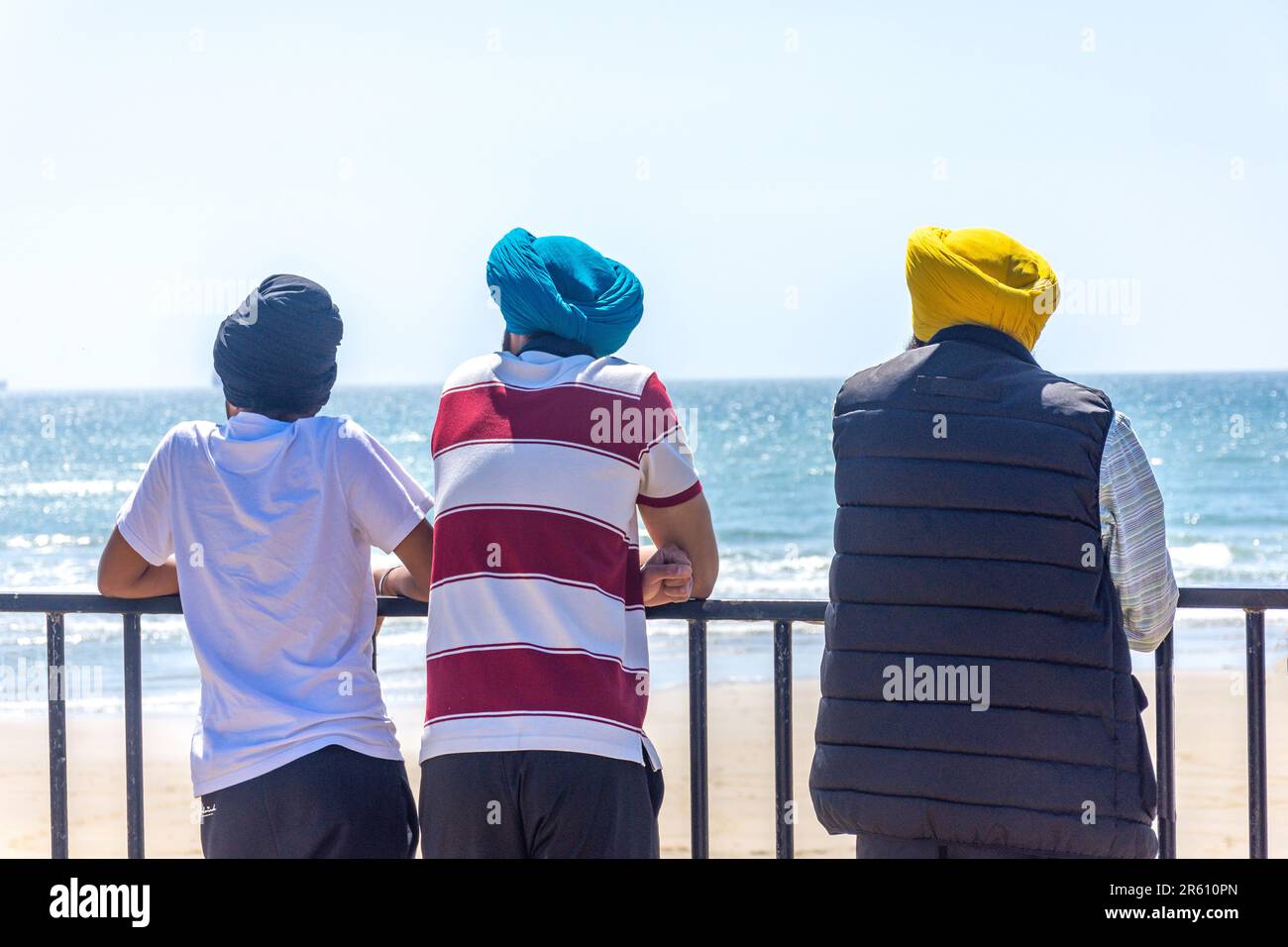 Famiglia Sikh che indossa turbani a Yaverland Beach, Yaverland, Isola di Wight, Inghilterra, Regno Unito Foto Stock