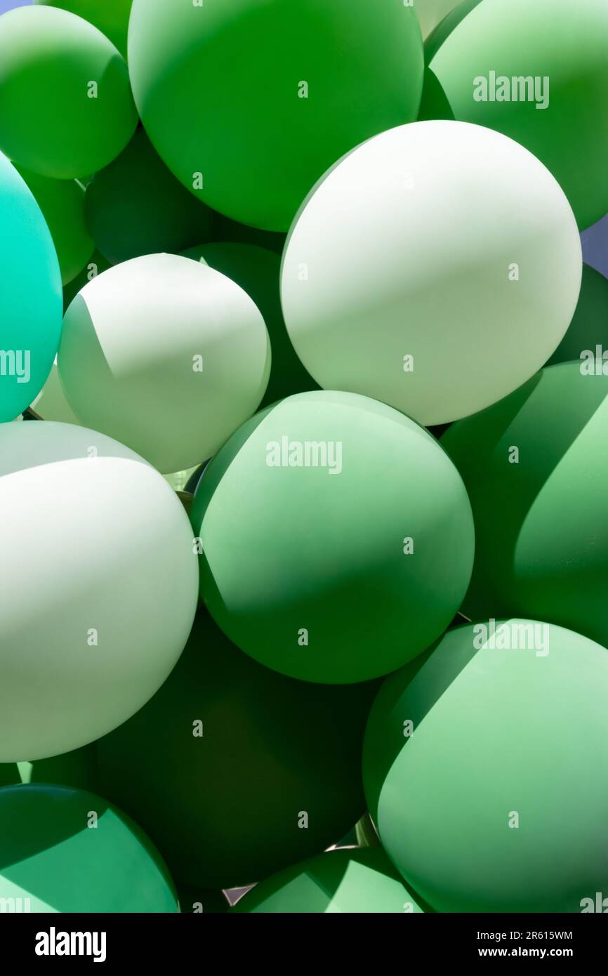 primo piano tiro verticale mazzo di palloncini in una varietà di sfumature di verde, buono per eco sfondo a tema con spazio copia Foto Stock