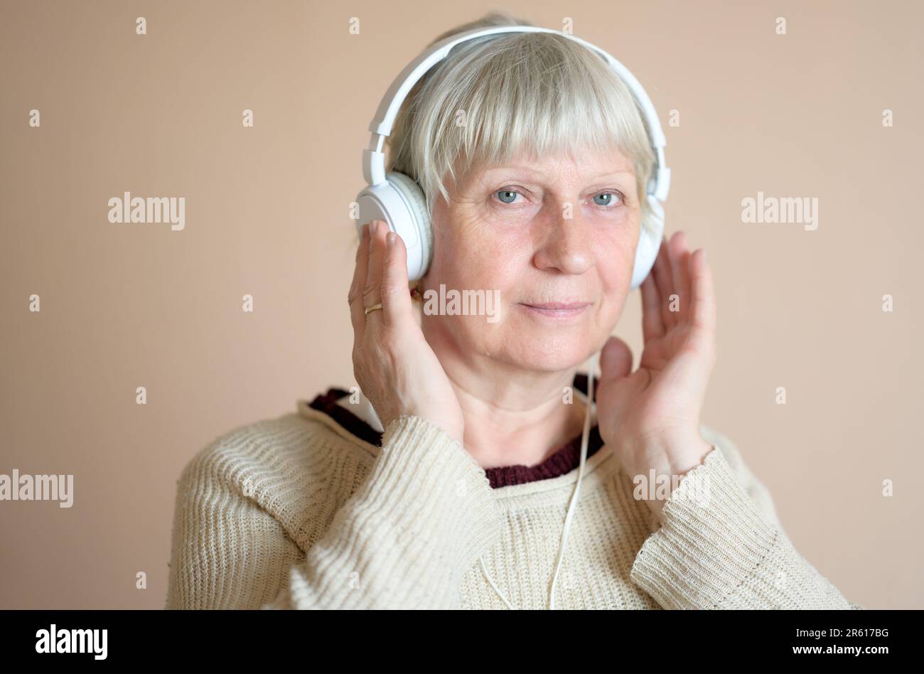 Bella donna di mezza età con cuffie a casa. Foto Stock
