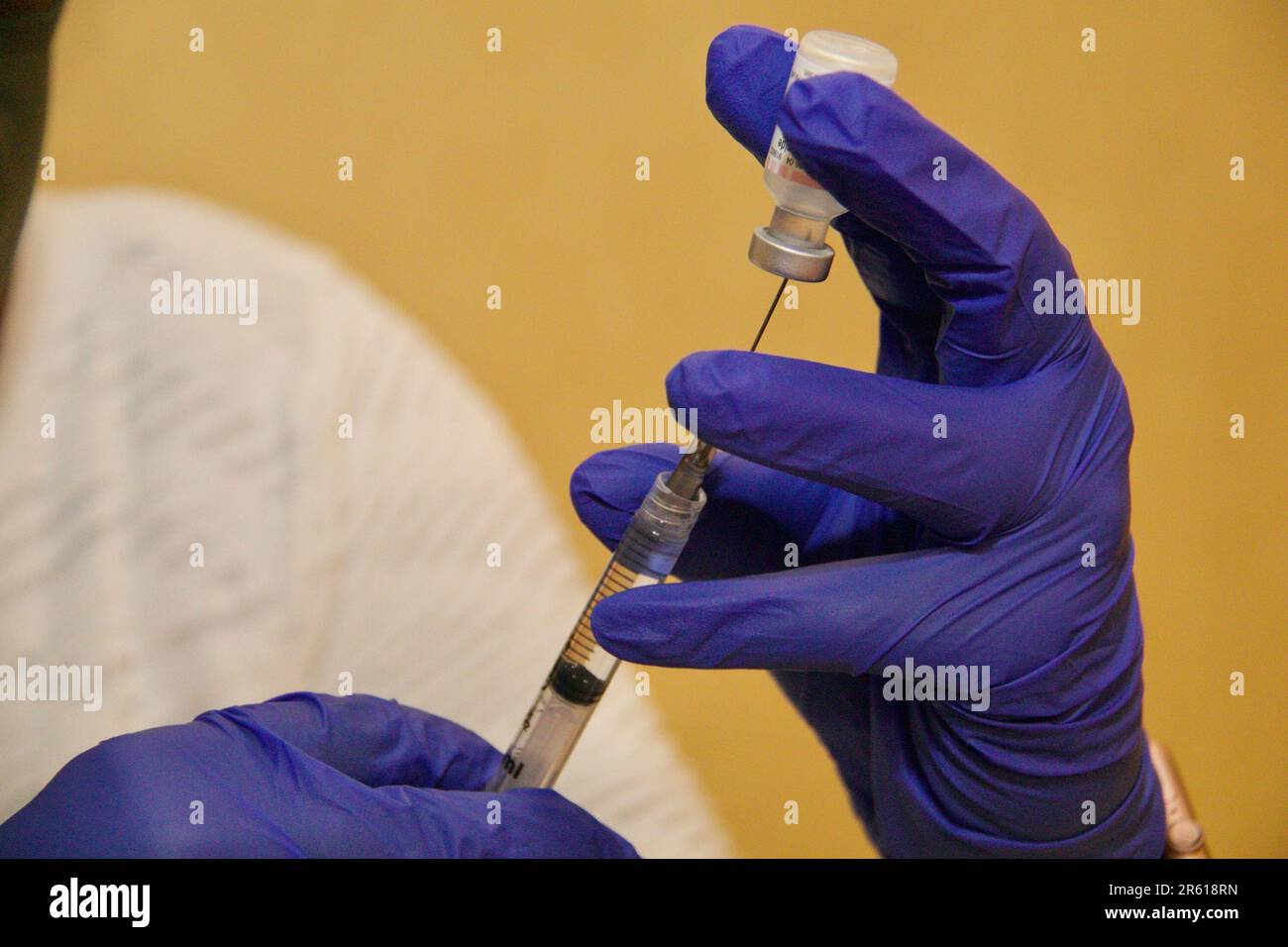 Un medico che inietta con ago ipodermico Foto Stock