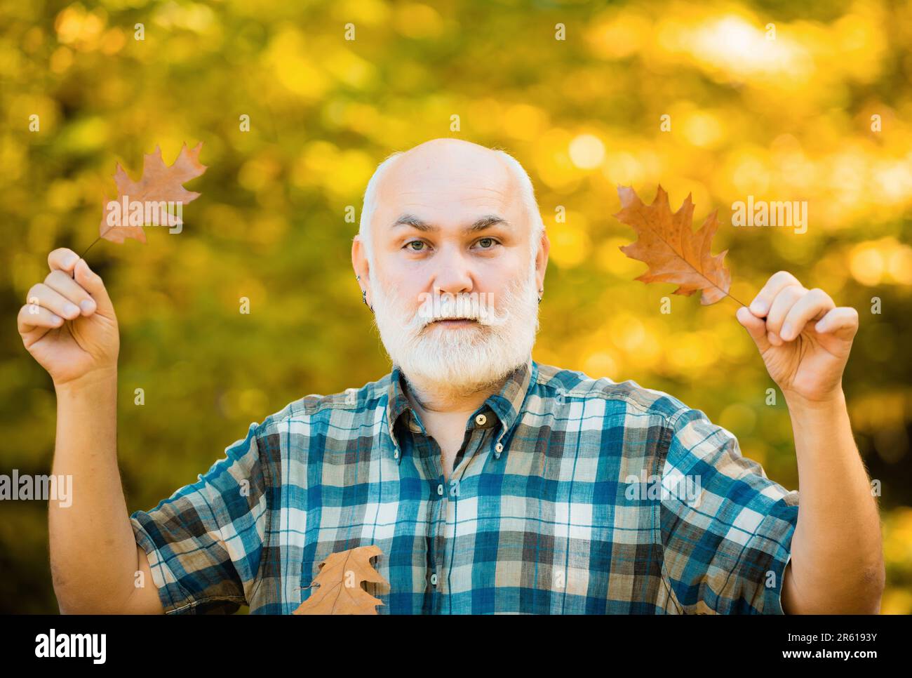 Felice uomo anziano escursioni in autunno nella natura. Vecchio solo nel parco autunnale. Foto Stock