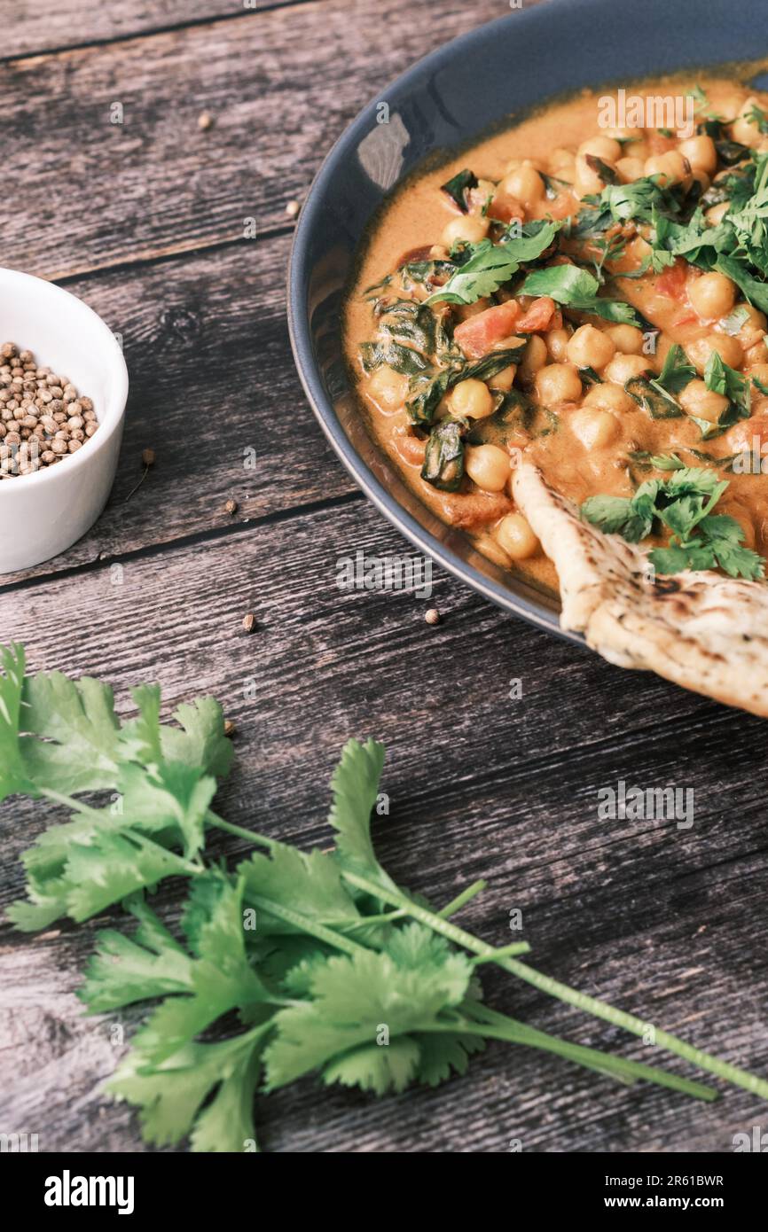 Curry vegano di ceci su sfondo scuro. Primo piano. Concetto di cibo vegetariano sano. Cucina tradizionale indiana. Foto Stock