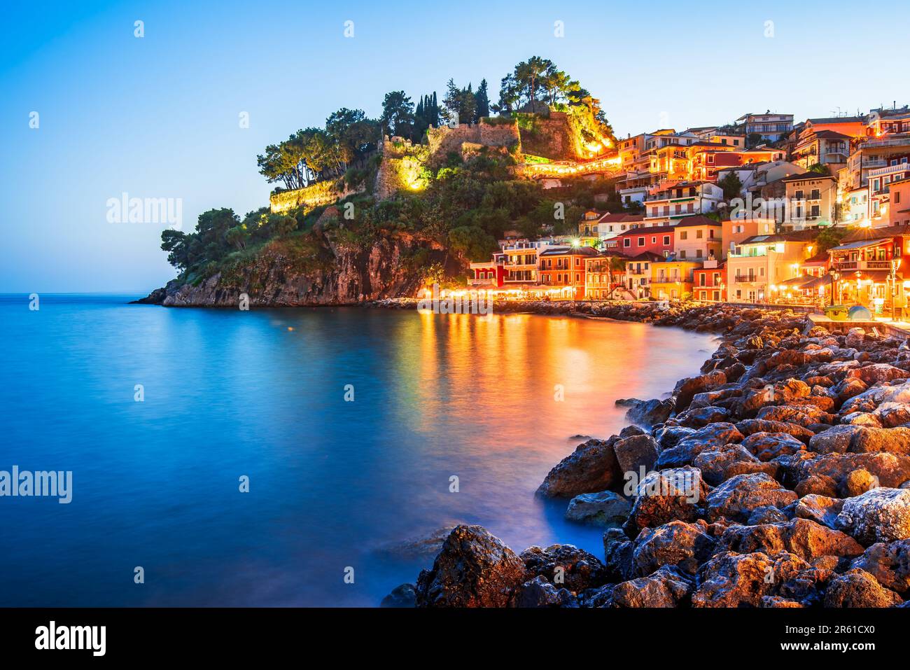 Parga, Grecia. Bella città costiera colorata in Epiro, vacanze greche. Ore blu tramonto illuminato Oldtown. Foto Stock