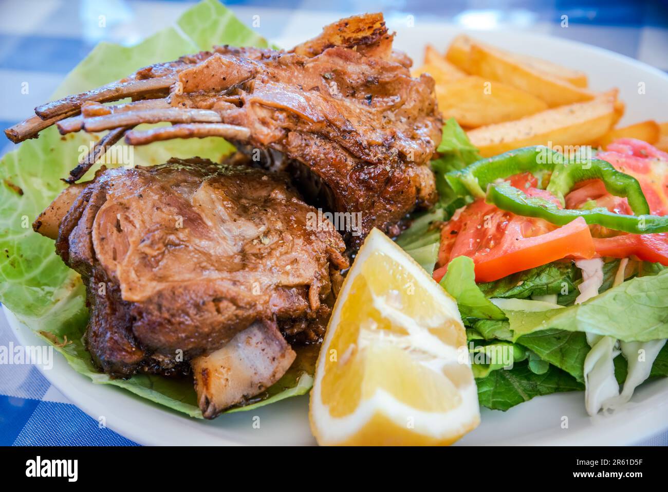 Succose costolette di agnello al forno infuse con erbe e spezie tradizionali greche, gustose e succulente esperienza culinaria greca. Foto Stock