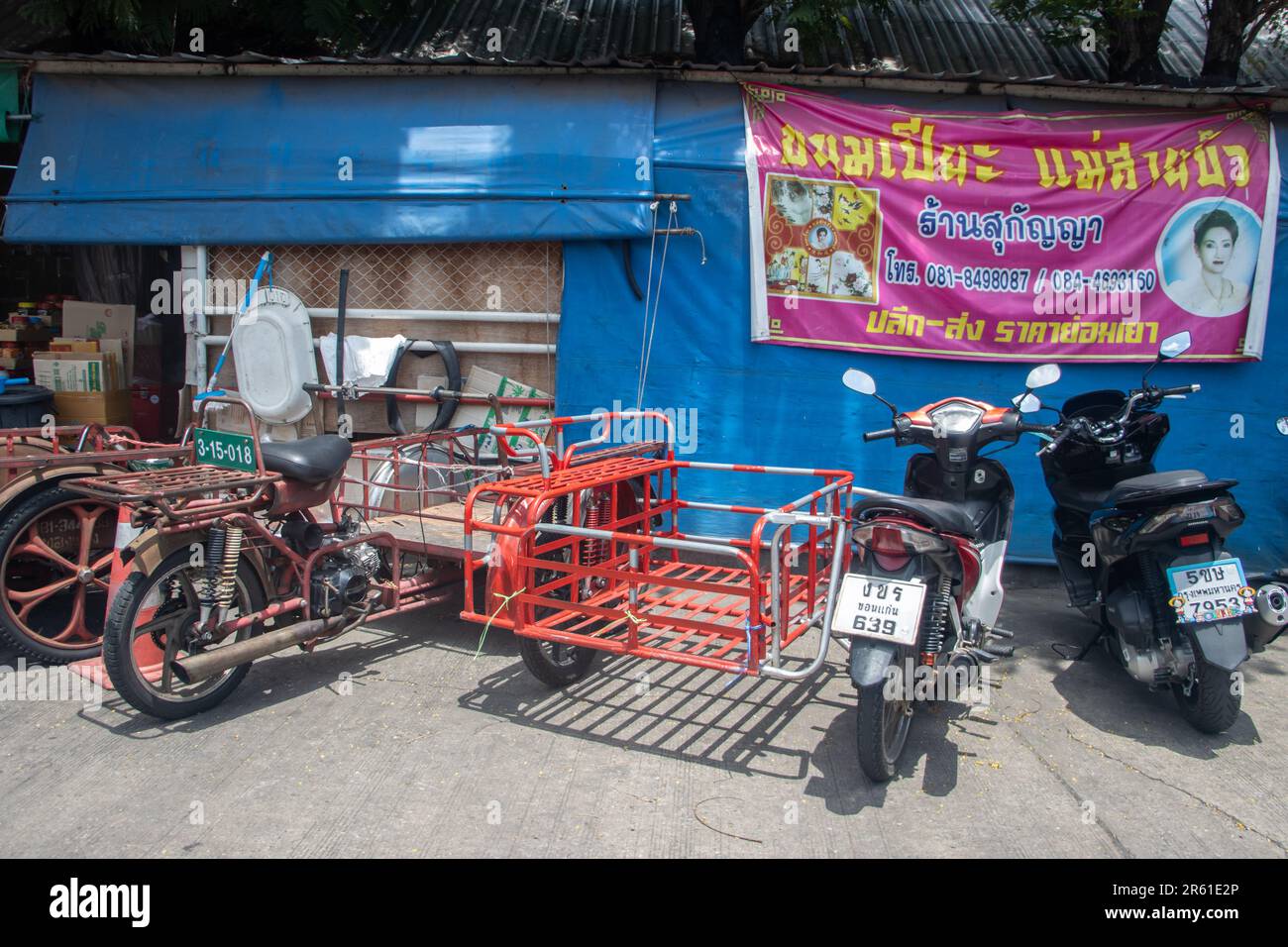 BANGKOK, THAILANDIA, 03 2023 GIUGNO, Una moto con carrelli per la consegna delle merci sono parcheggi al mercato Foto Stock