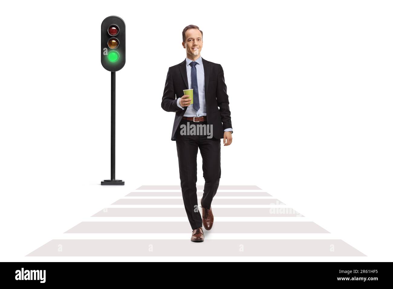 Ritratto completo di un uomo d'affari che attraversa la strada con una tazza di caffè da asporto isolato su sfondo bianco Foto Stock