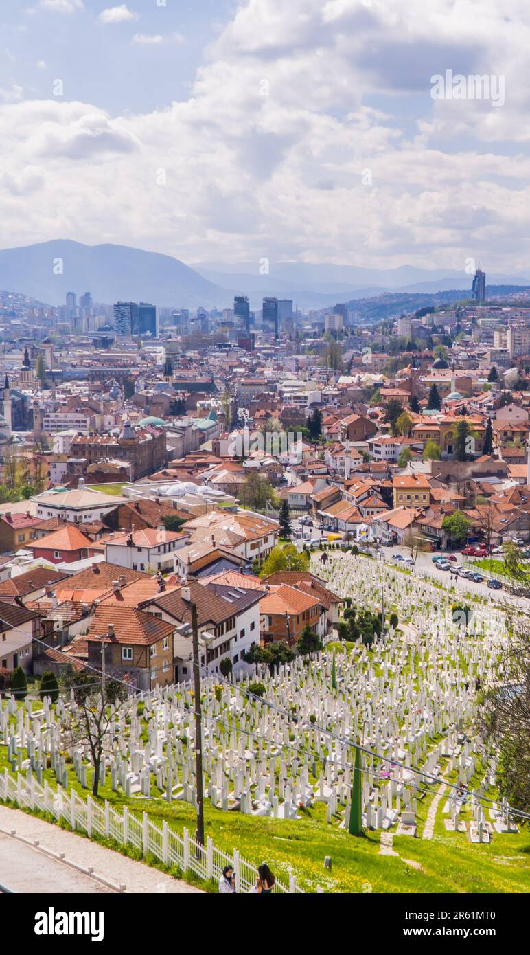 Una vista panoramica della pittoresca Sarajevo immersa nelle colline con un cimitero in primo piano Foto Stock