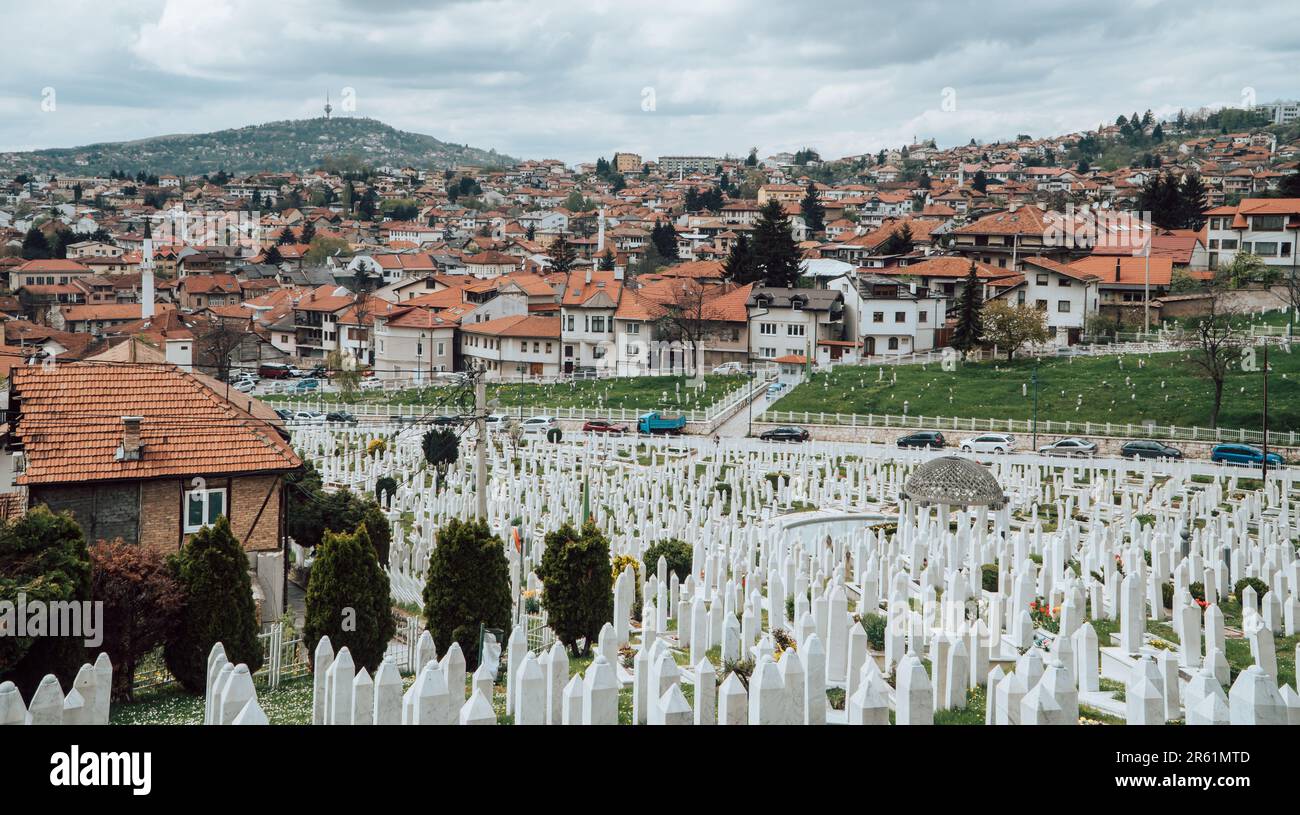 Una vista panoramica della pittoresca Sarajevo immersa nelle colline con un cimitero in primo piano Foto Stock
