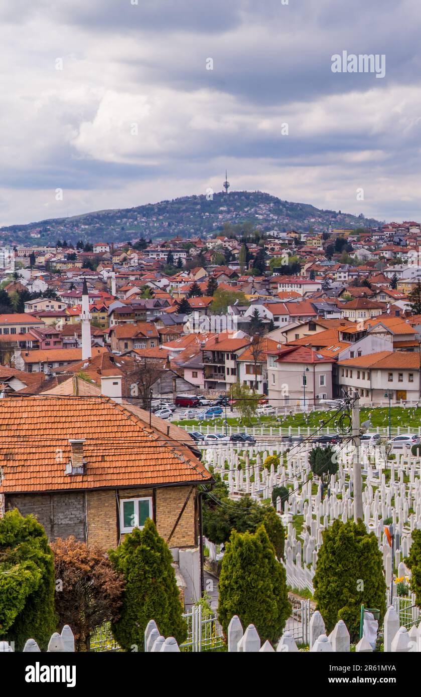 Una vista panoramica della pittoresca Sarajevo immersa nelle colline con un cimitero in primo piano Foto Stock