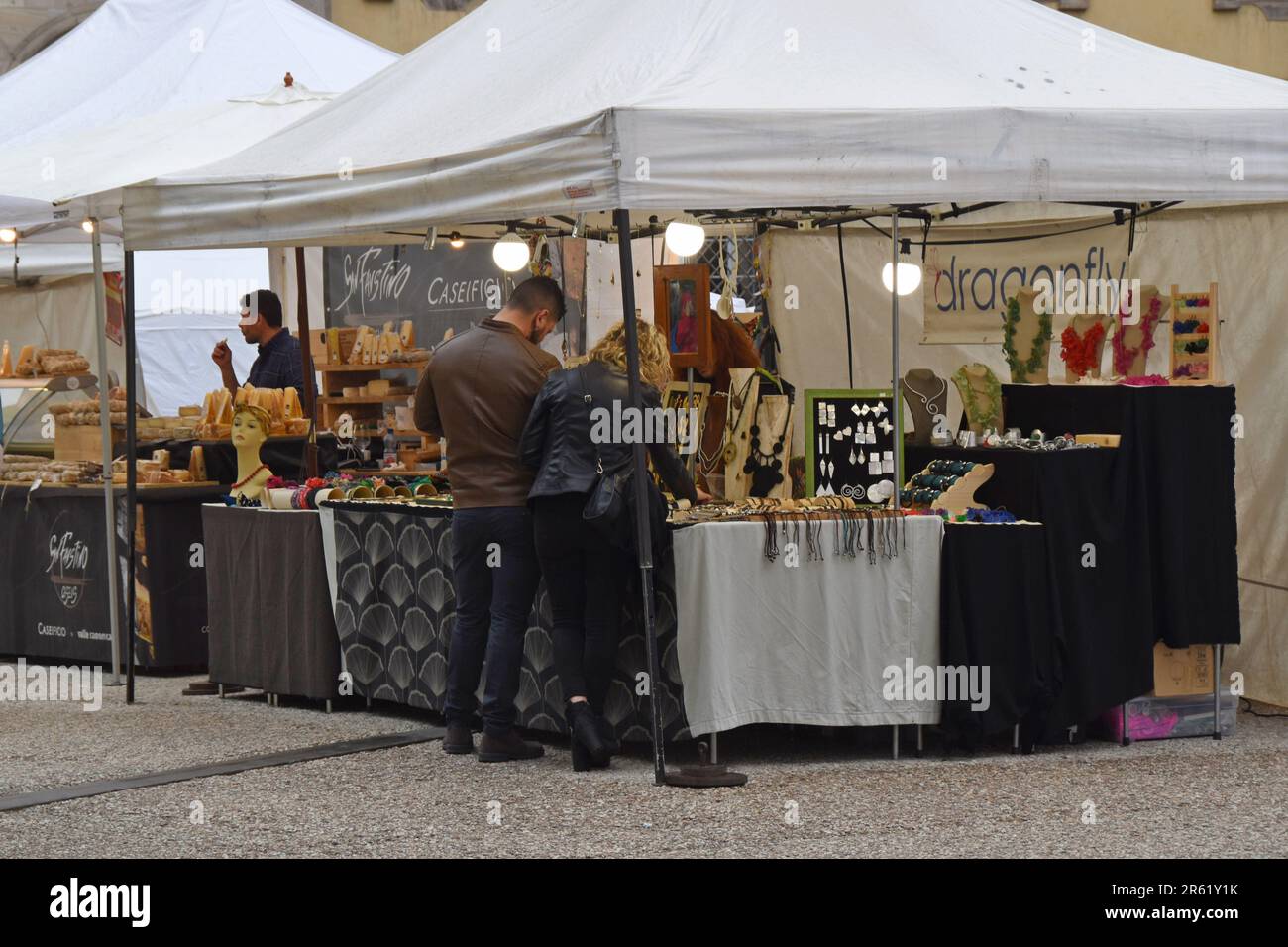 Le persone che navigano in bancarelle presso il mercato artigianale del cibo e dell'artigianato in Piazza Napoleone, Lucca, Toscana, Italia, aprile 2023 Foto Stock