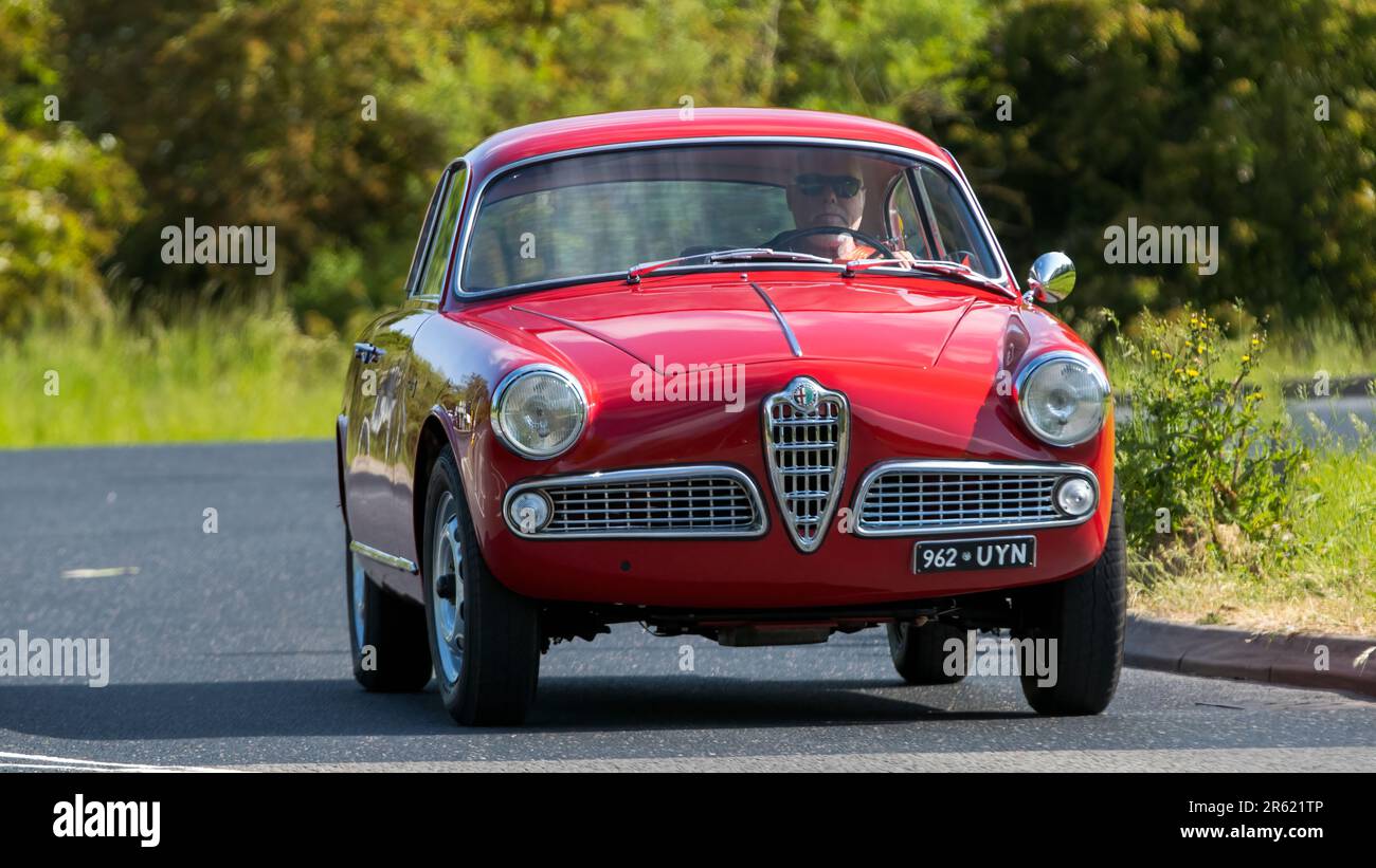 Stony Stratford,UK - Giugno 4th 2023: 1959:00 Red Alfa Romeo Giulietta Sprint auto classica in viaggio su una strada di campagna inglese. Foto Stock