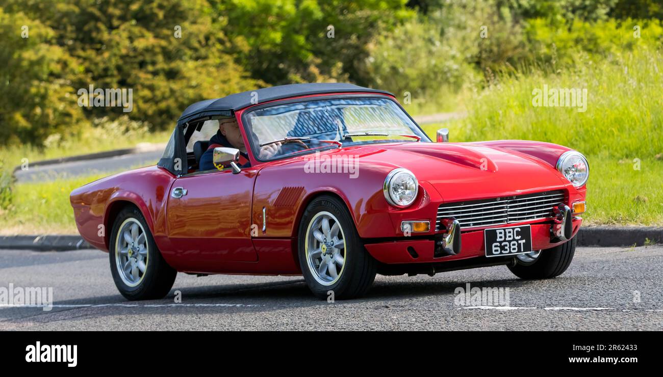 Stony Stratford, Regno Unito - 4th 2023 giugno: 1978 rosso TRIONFO SPITFIRE auto classica in viaggio su una strada di campagna inglese. Foto Stock