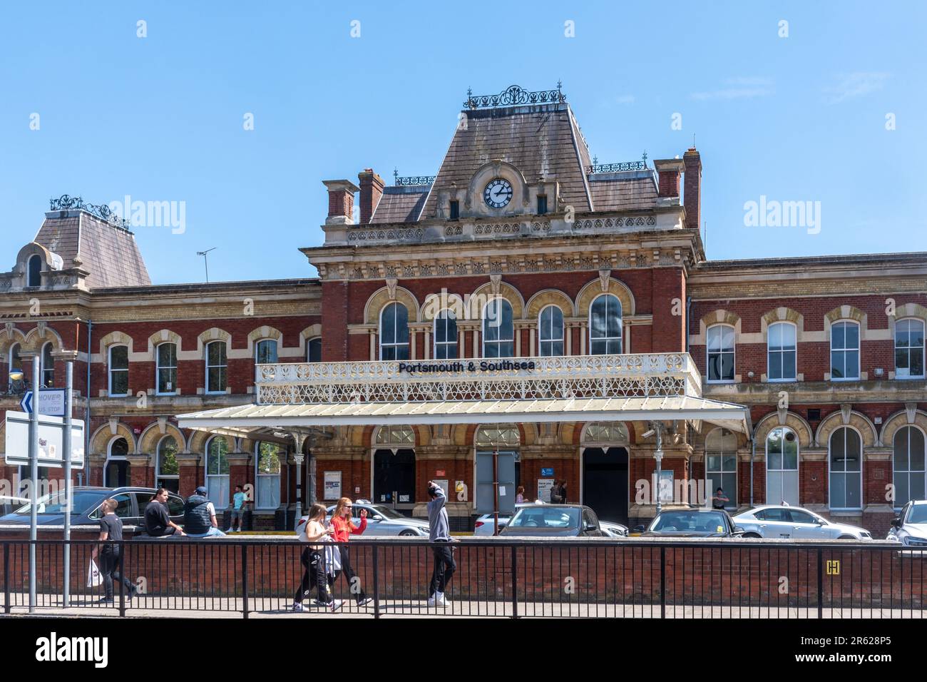 Portsmouth e la stazione ferroviaria di Southsea con la gente che cammina oltre, Hampshire, Inghilterra, Regno Unito, un edificio classificato di grado II Foto Stock