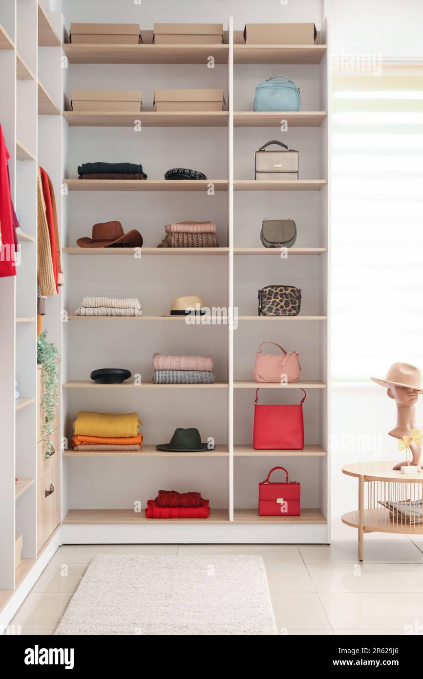 Scaffali con abiti e accessori eleganti in boutique Foto Stock